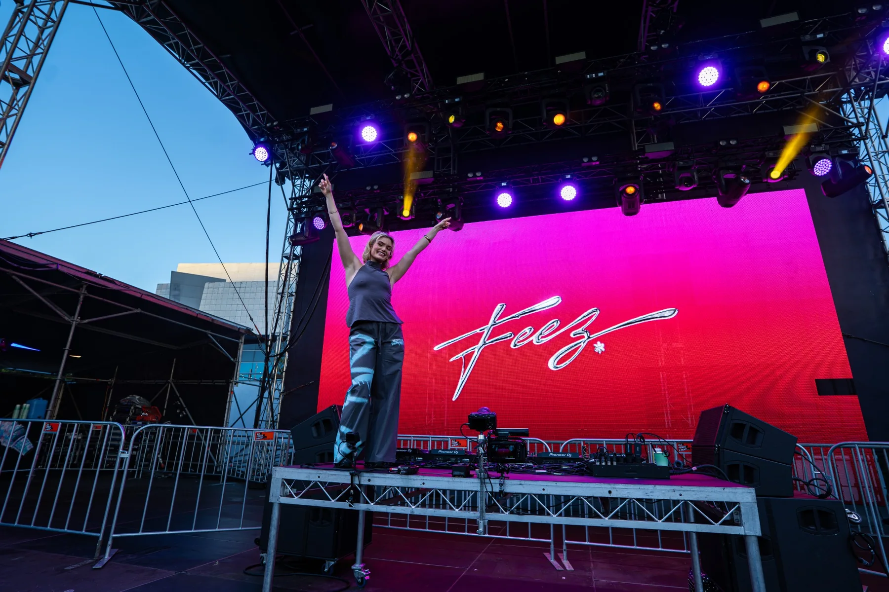 Festival performer standing above the DJ booth